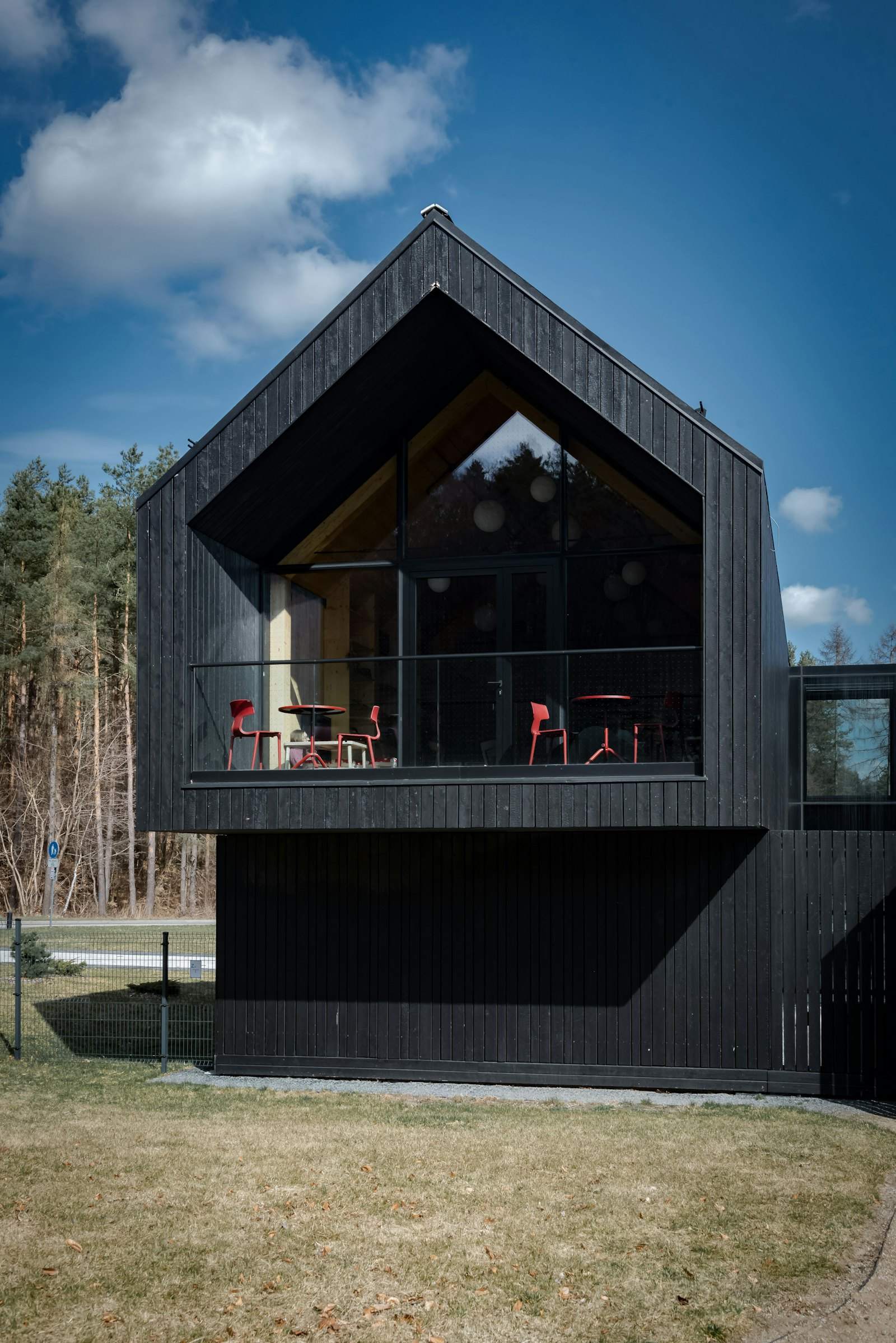 Modern black vertical-board house with a large glass gable