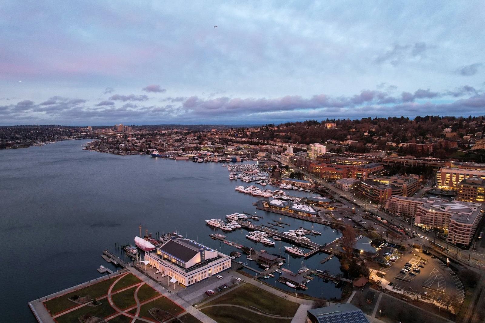 Waterfront city with boats in a harbor at dusk
