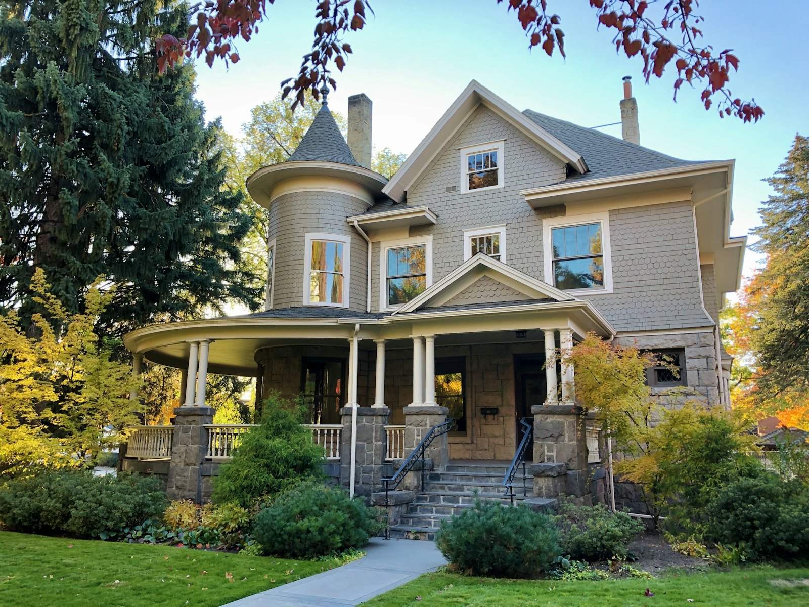 Gray historic house with a turret and a wide front porch