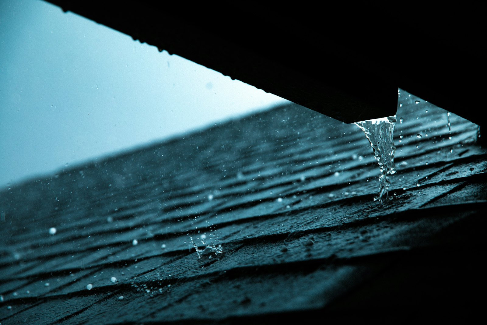 Rain water dripping off a roof edge