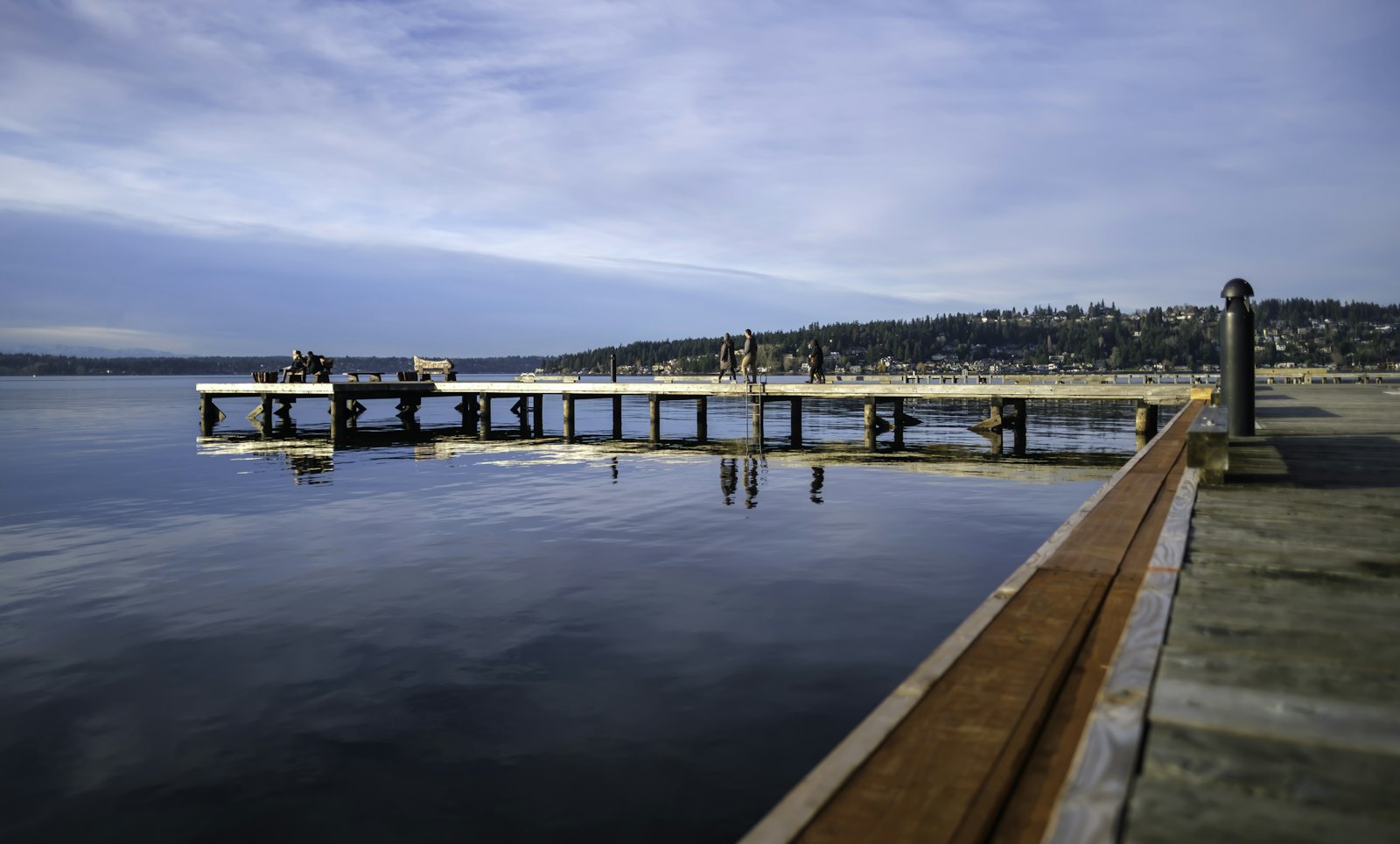 Wooden pier stretching into a calm lake at dusk