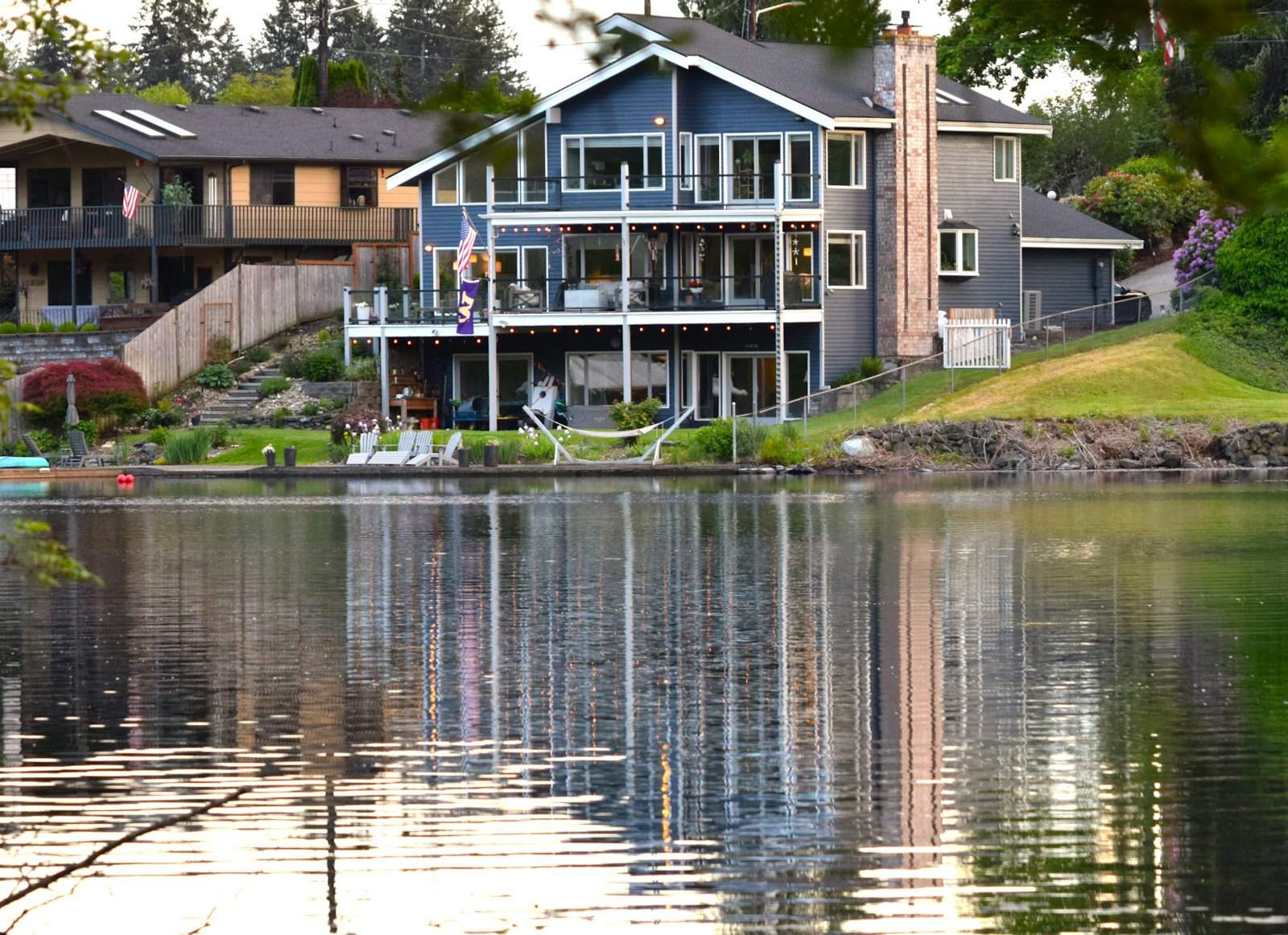 Two-story homes with decks above a calm lake