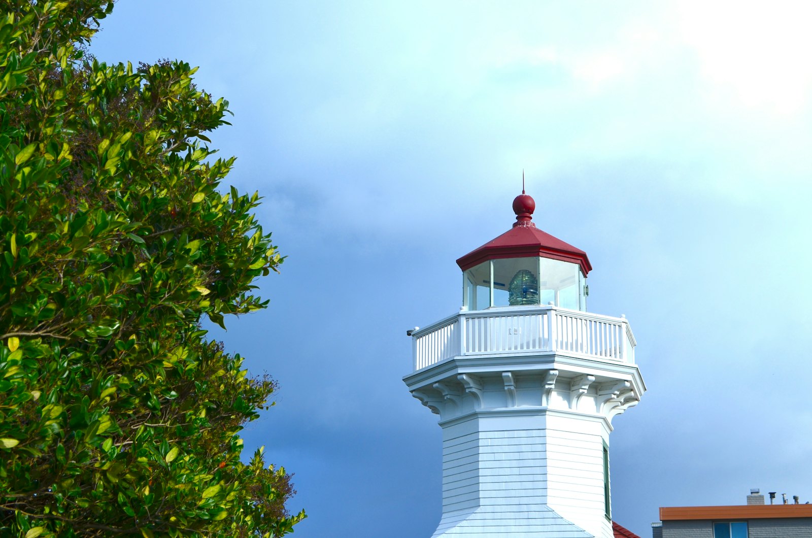 White lighthouse with a red top against a blue sky