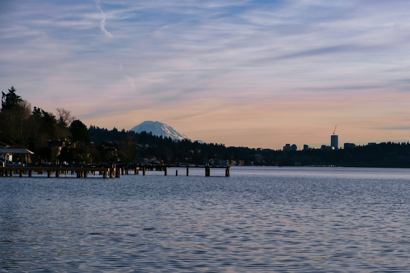 Lake at sunset with a pier and a distant mountain