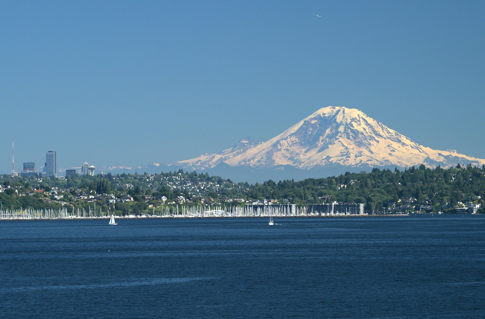 Mount Rainier rising above a waterfront city and marina
