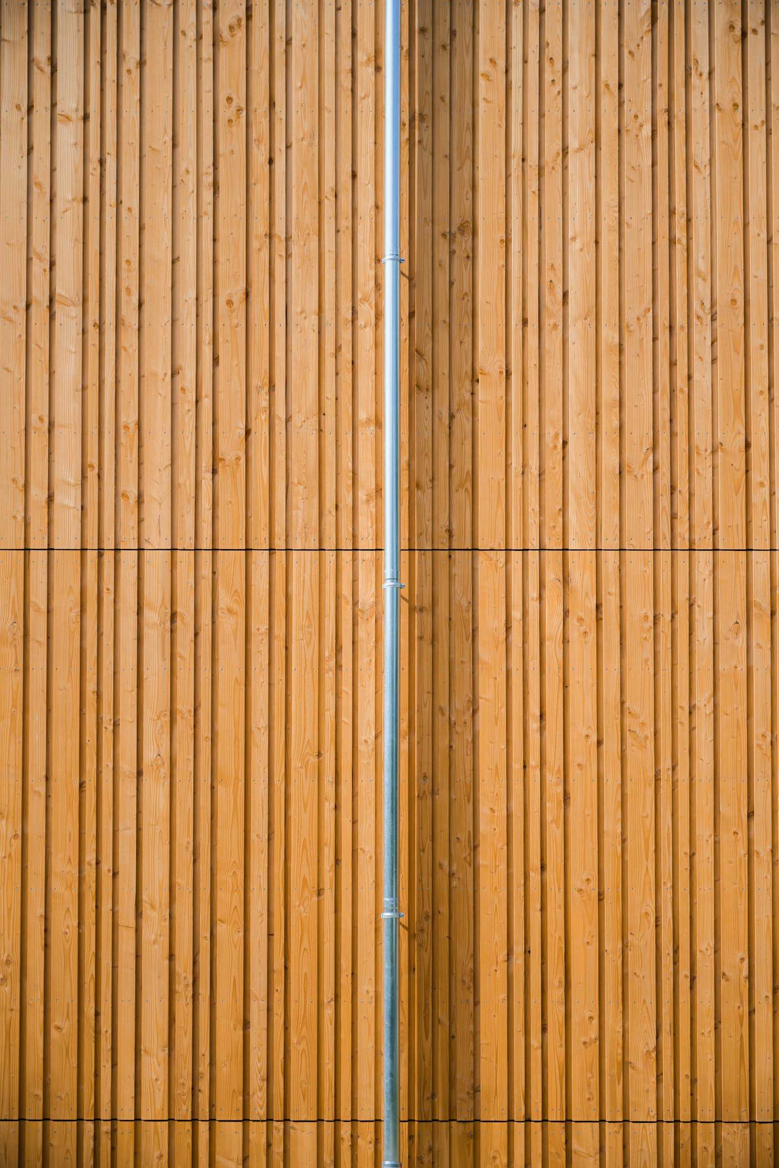 Vertical natural wood boards with a downspout
