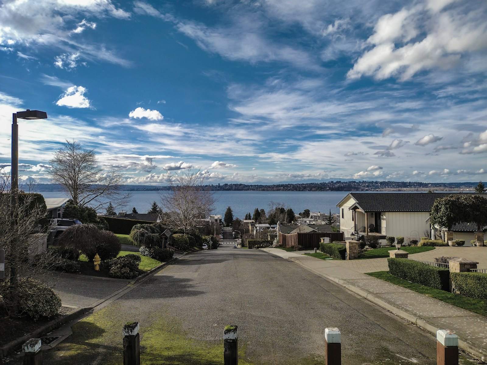 Residential street sloping down toward a lake view
