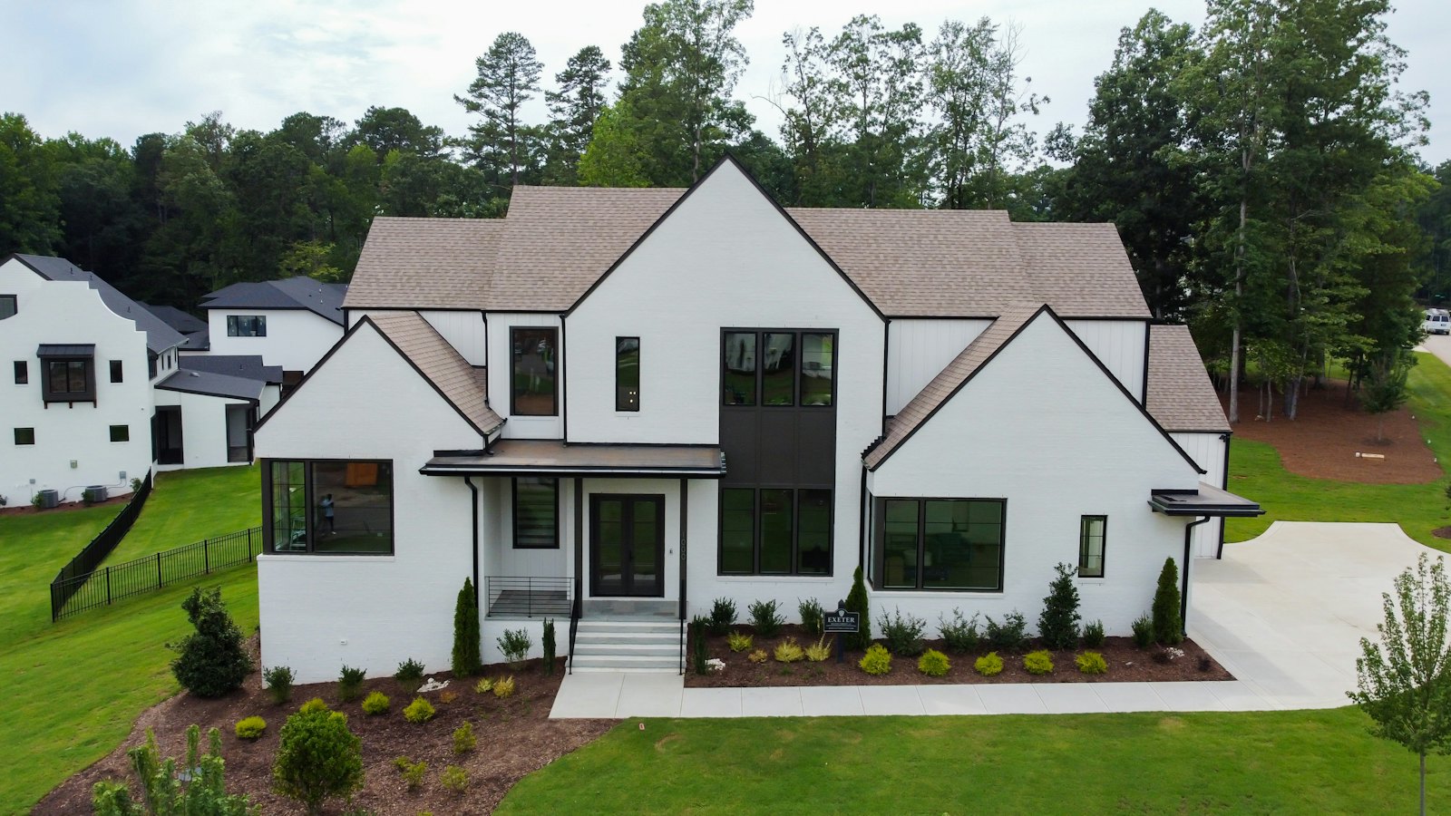 Large new white house with dark roofs and black windows