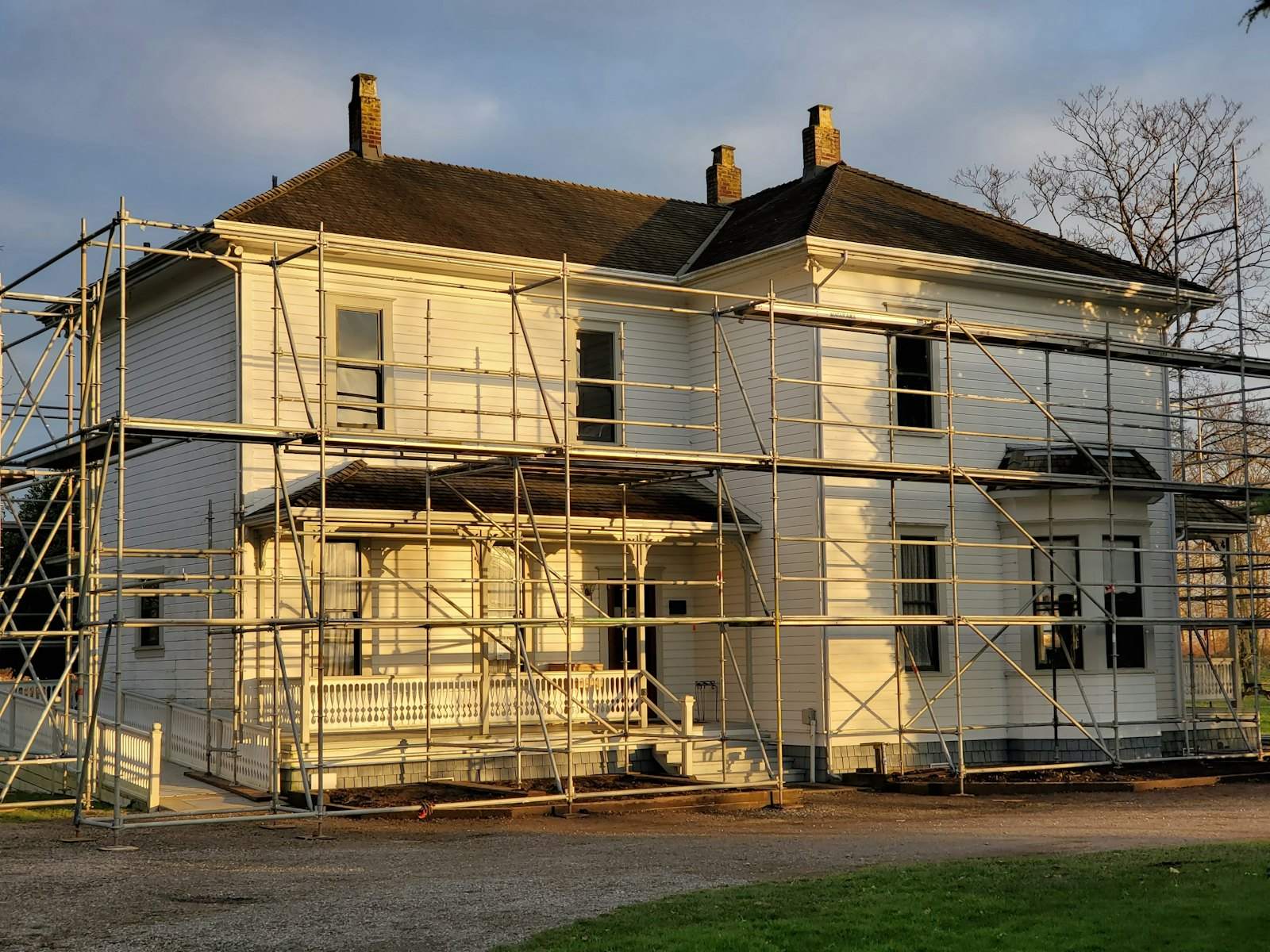 Two-story house wrapped in scaffolding during exterior renovation